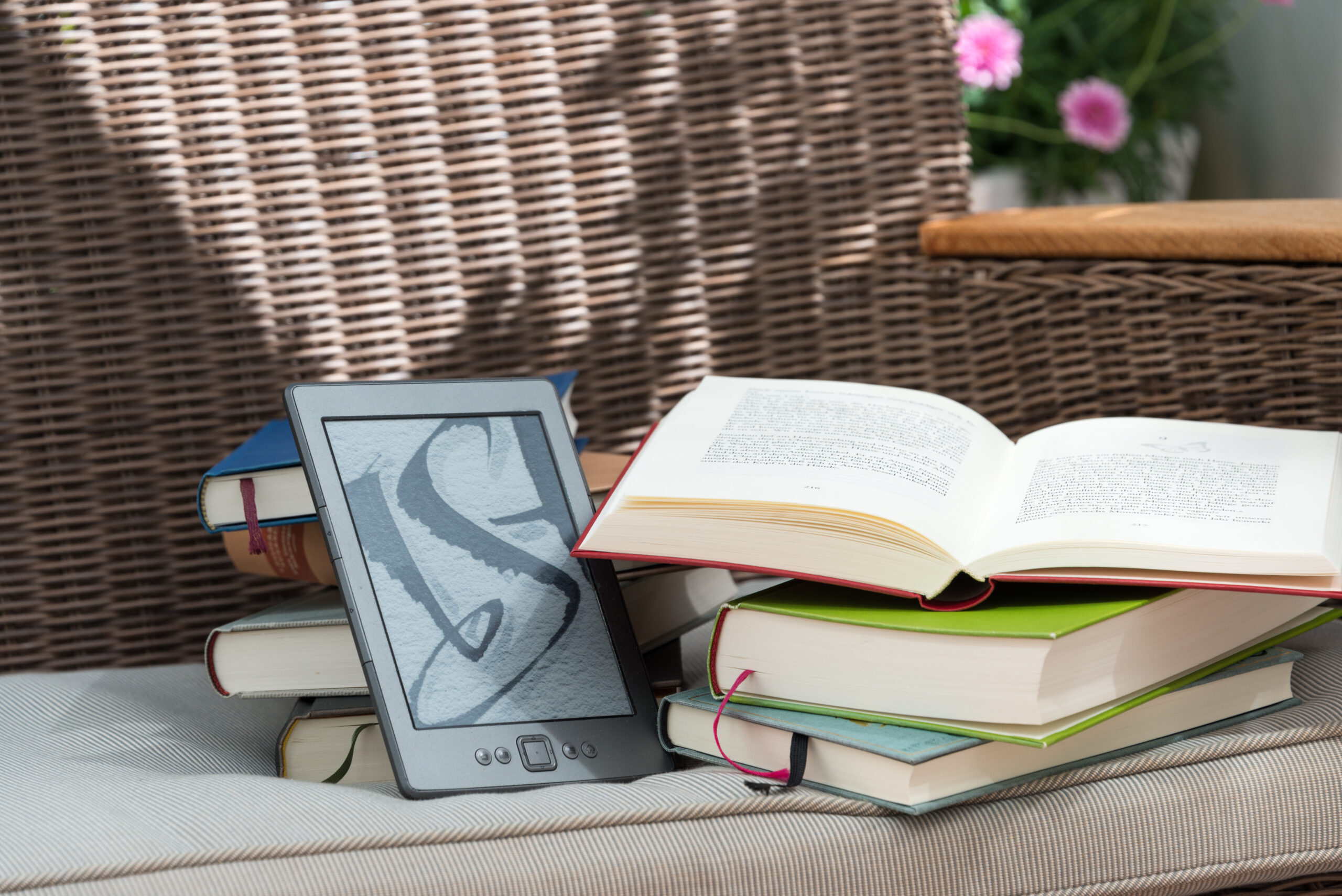 電子書籍リーダーと積み重ねた紙の本